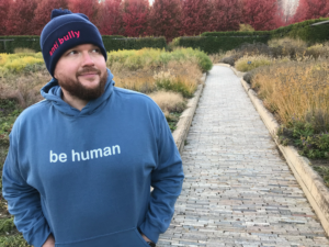 Jeffrey Alman wearing a blue sweatshirt and a hat with the words Anti-bullying